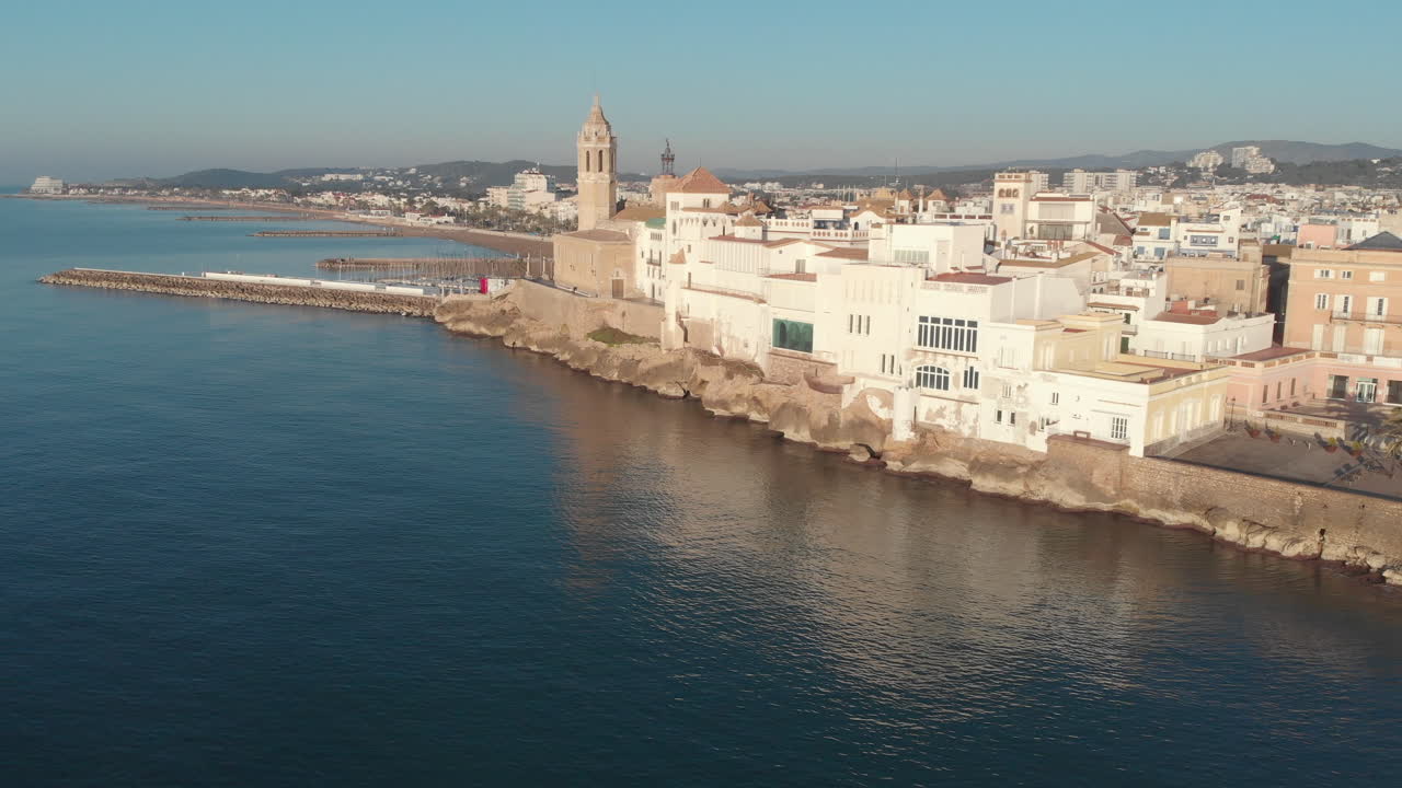 disparo de drones que rodea la antigua ciudad costera durante la hora de la mañana, donde los edificios se reflejan bellamente en el mar en calma debajo