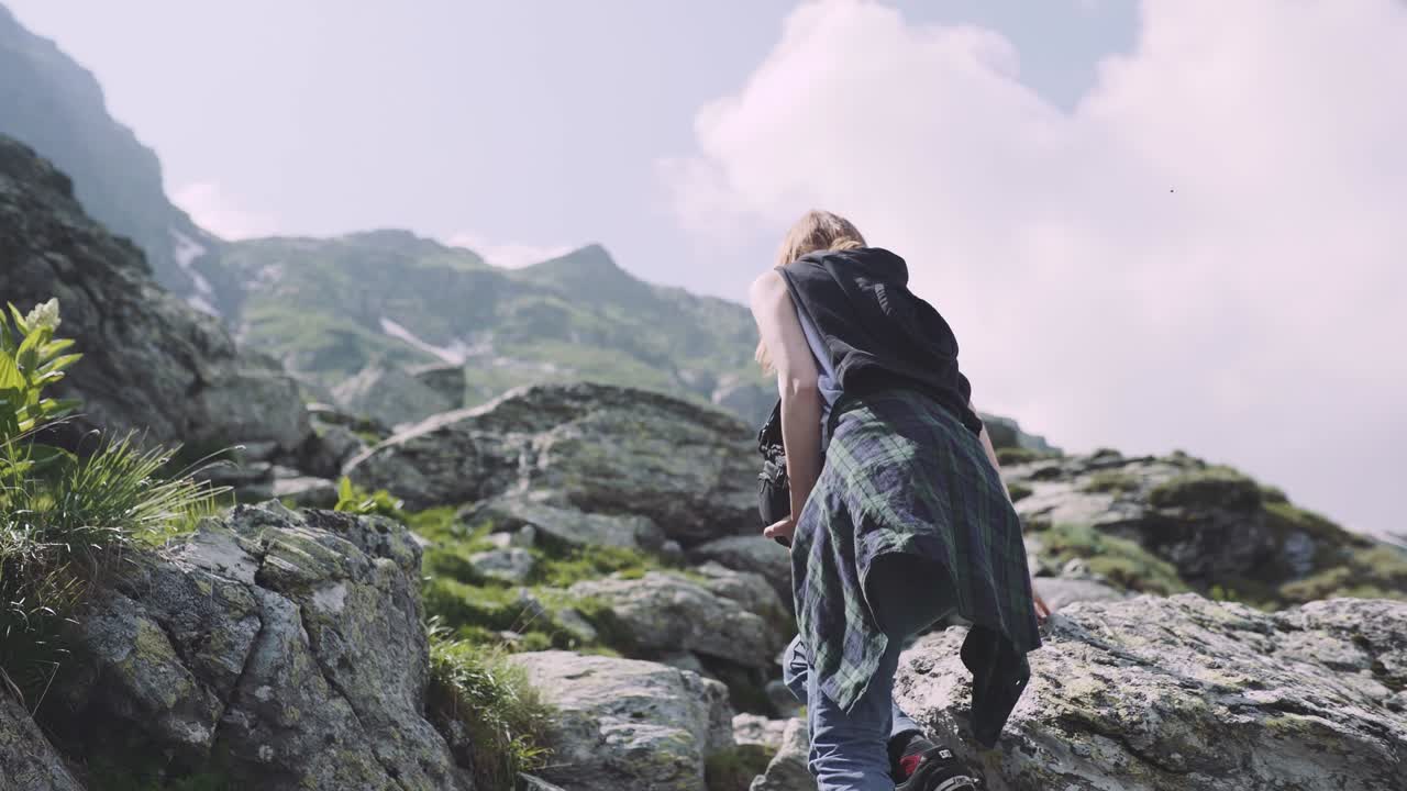 una joven excursionista sube montañas con una cámara fotográfica. transfagarasan, montañas de los cárpatos en rumania