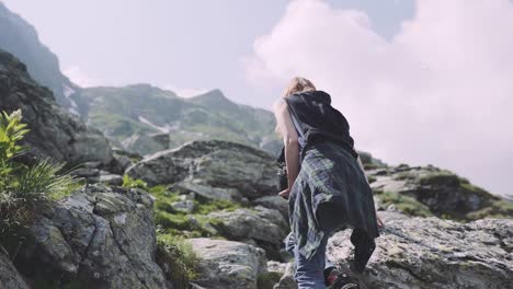 a young woman hiker climbs mountains with photo camera. transfagarasan, carpathian mountains in romania