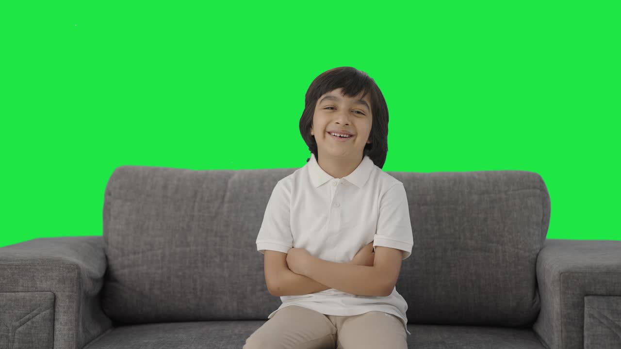 niño indio feliz mirando la pantalla verde de la cámara