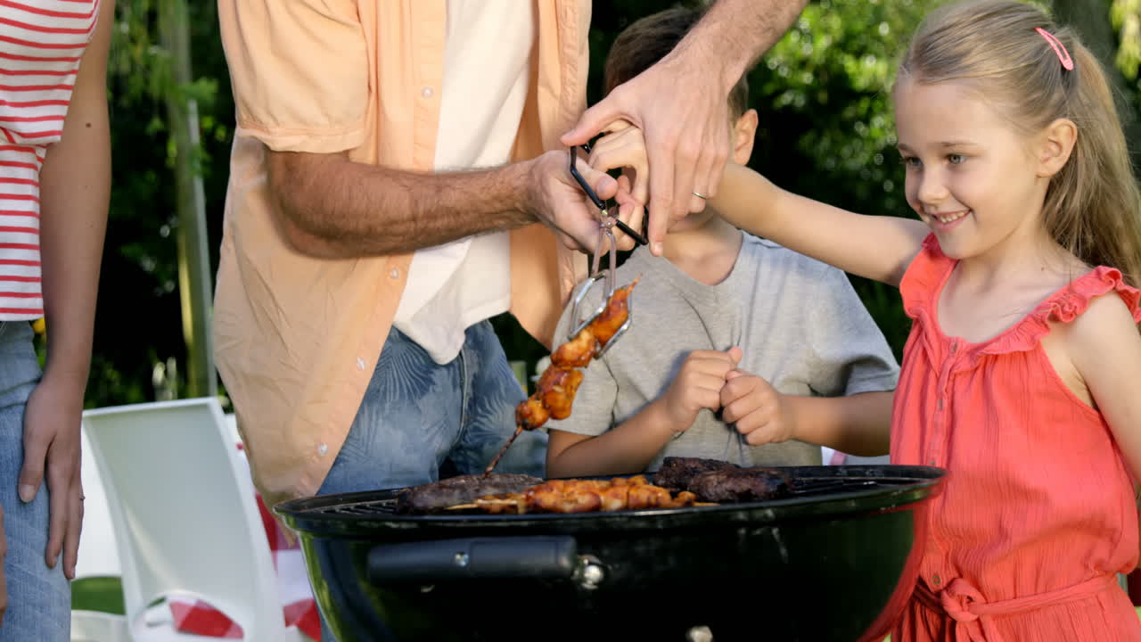 cerca de la familia feliz está comiendo una barbacoa en el jardín