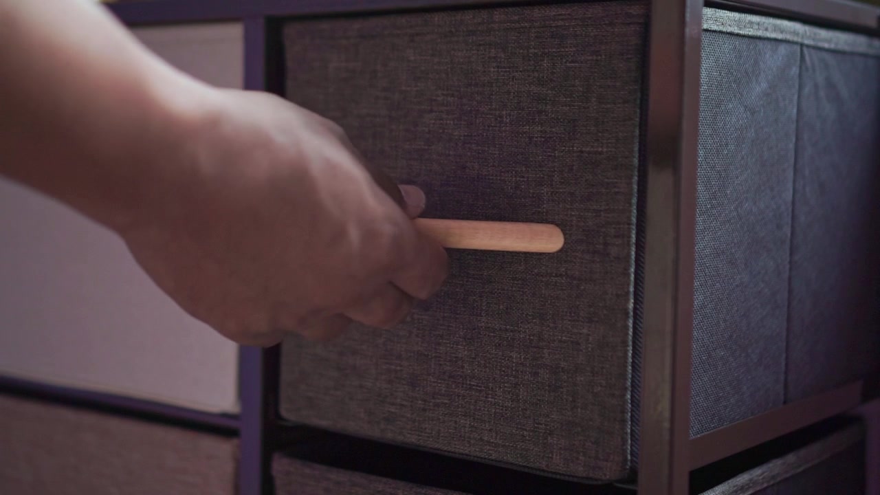 hand opening fabric storage drawer at home. Organization, home storage, and interior decor concept, indoor lifestyle footage.