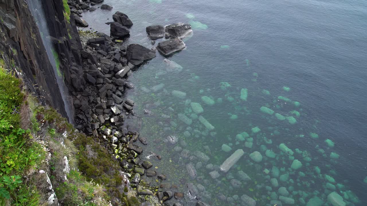 el agua de la famosa cascada de melt falls cae en la enorme profundidad con grandes piedras en el lecho marino del mar azul claro