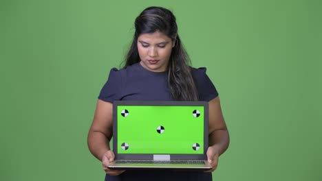 joven sobrepeso hermosa mujer de negocios india contra fondo verde