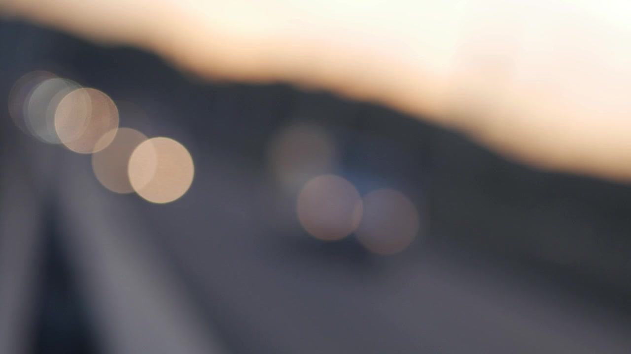Luci bokeh sfocate del traffico in movimento su una strada