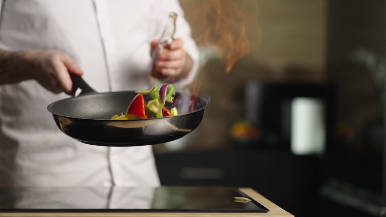 Chef cooking vegetables in a frying pan