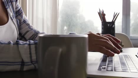 Frau-Arbeitet-Am-Laptop,-Während-Sie-Am-Tisch-Sitzt