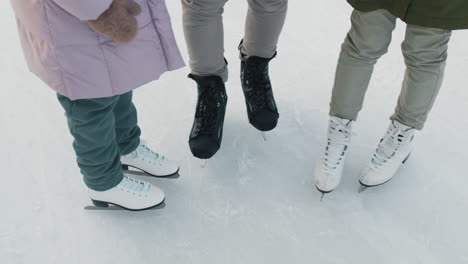 three people ice skating