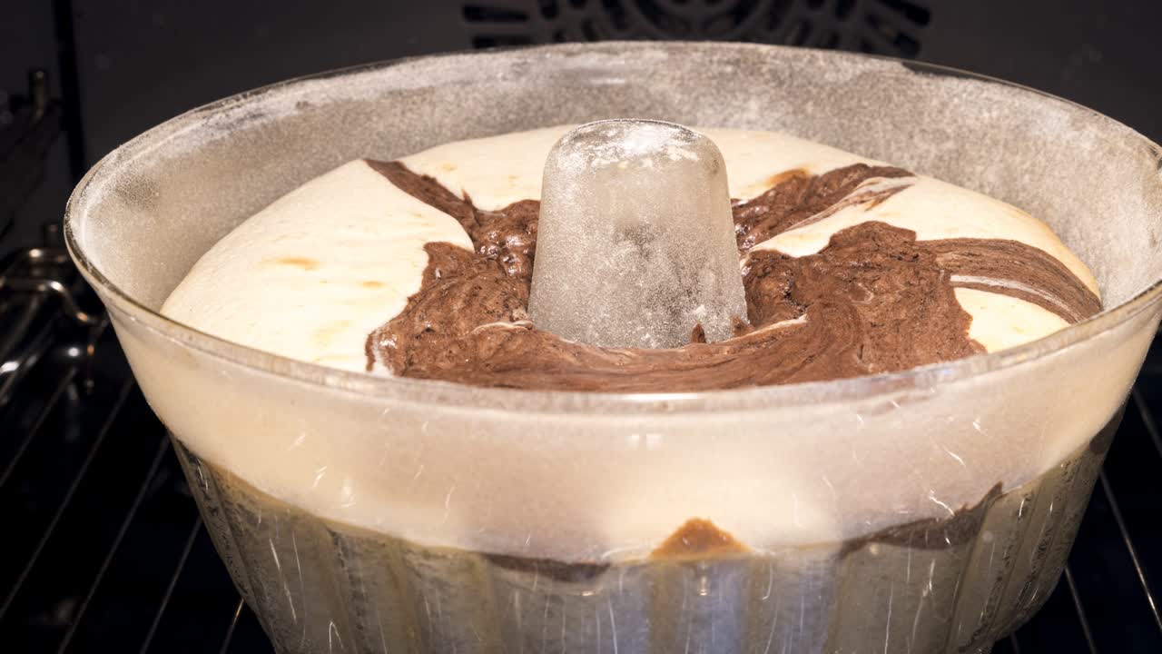 유리 모형에서 전통적이고 맛있는 트 케이크를 는 것: 양식의 가장자리 위로 천천히 상승하는 페이스트리, 집에서 만든 스폰지 대리석 케이크, 오븐의 앞면, 타임 스 비디오