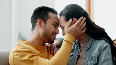 couple, forehead touch and kiss on sofa with love