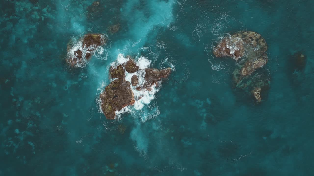 Le onde si infrangono sulle rocce sulla costa di un mare