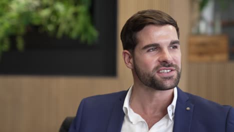 a young smart businessman with a dark beard talking and laughing in the workplace