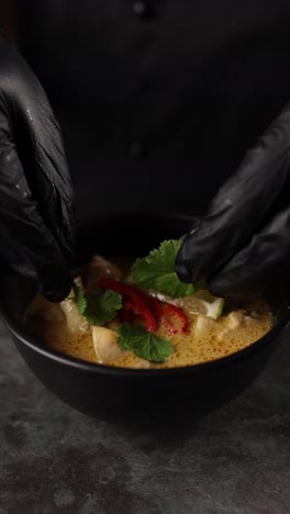 chef preparing a bowl of thai green curry