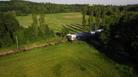 video aéreo de un tren local que pasa, conduciendo a través de la hermosa campiña checa