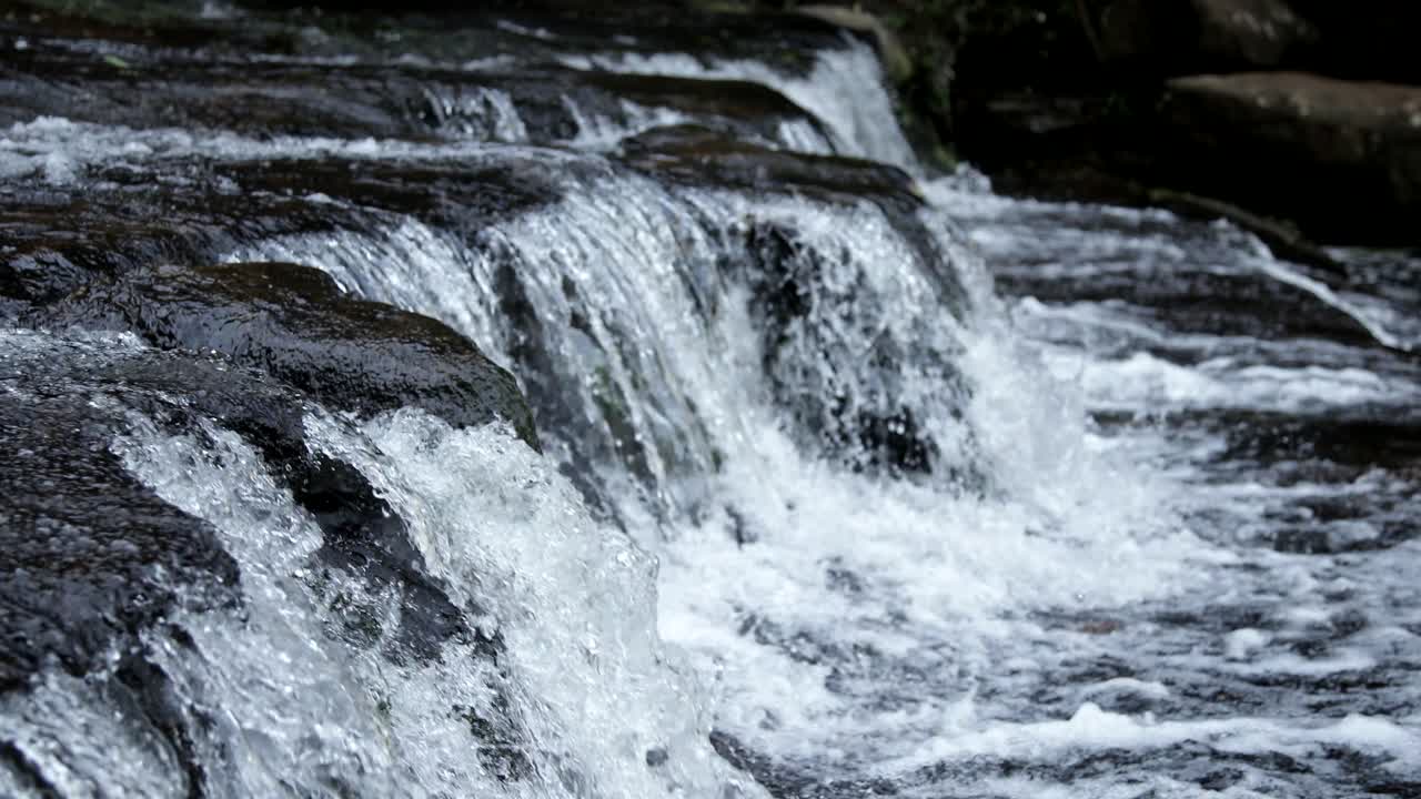 Detaljbilde av vann som renner av steinene