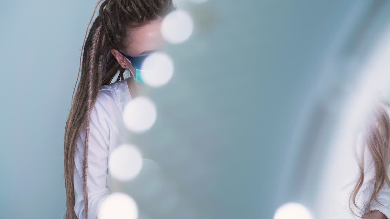 보호 안경을 쓴 화장품 전문의가 클리닉에서 레이저 탈모를 합니다.