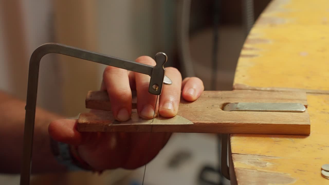 el artesano se centra en la elaboración de diseños detallados de madera en un taller, utilizando herramientas manuales y mostrando técnicas tradicionales.