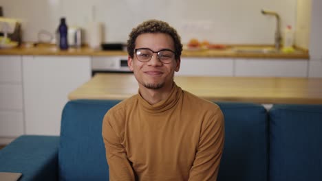 Portrait-young-man-in-trendy-glasses-relaxing-sitting-on-the-sofa-in-home-living-room