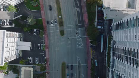 top down panning view of wide multilane trunk toad leading between modern high rise buildings in urban borough. miami, usa