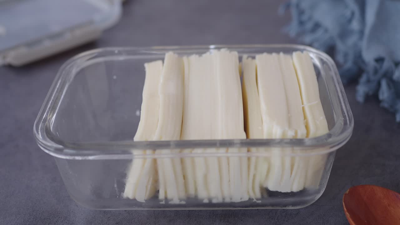 cortar a mano y almacenar el queso en rodajas en un recipiente de vidrio