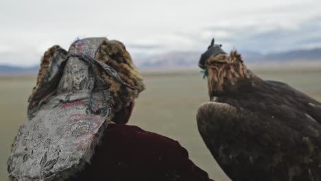 Golden-eagle-hunter,-Mongolian-falconer-and-bird-ready-for-hunt,-Altai-Mountains