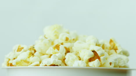 Ein-Glas-Popcorn-Auf-Weißem-Hintergrund-Dreht-Langsam-4k-Videos