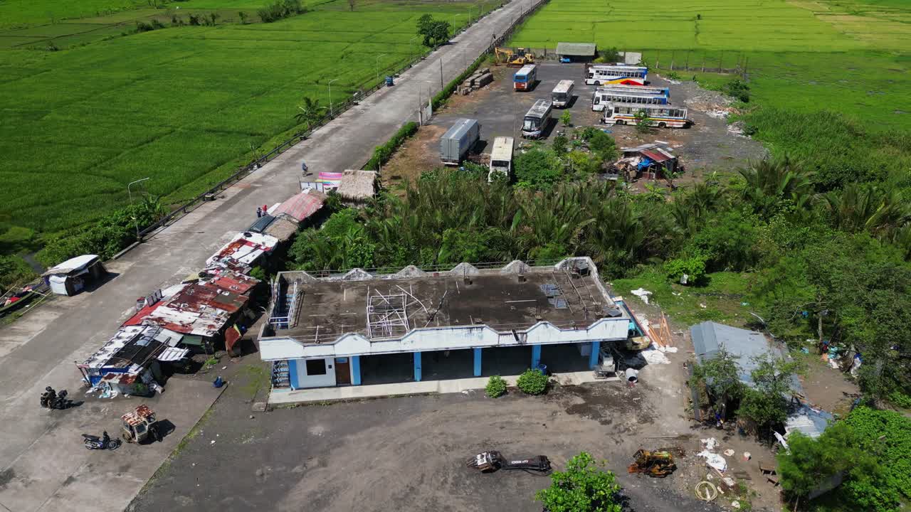 Aerial drone shot of squatter area with dilapidated rooftops and abandoned buildings at lush tropical province in Malilipot, Albay, Philippines