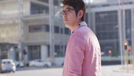 asian man hailing a taxi while standing on the hailing a city street