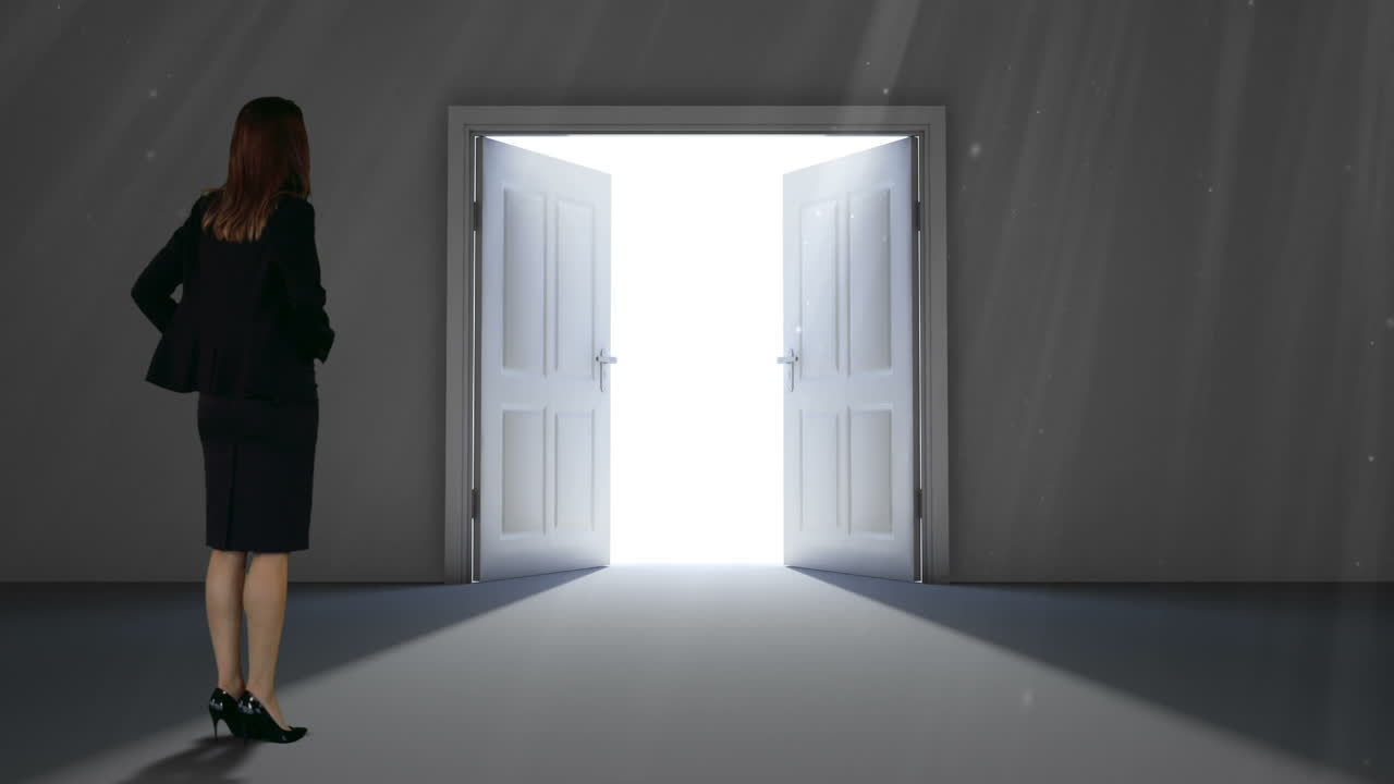Businesswoman watching door open to light
