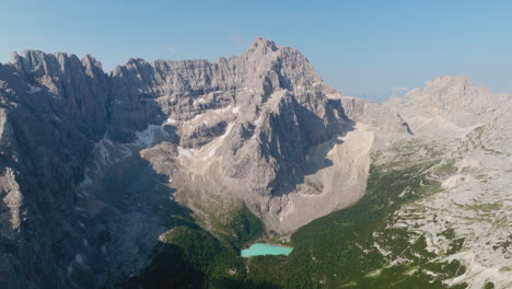 breathtaking aerial panorama of lake sorapis in the dolomites during spring, showcasing its turquoise waters surrounded by melting snow and rugged alpine peak