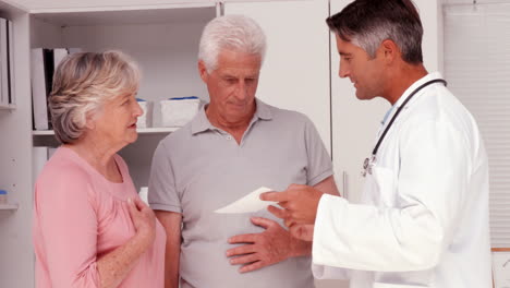 doctor explaining prescription to elderly couple