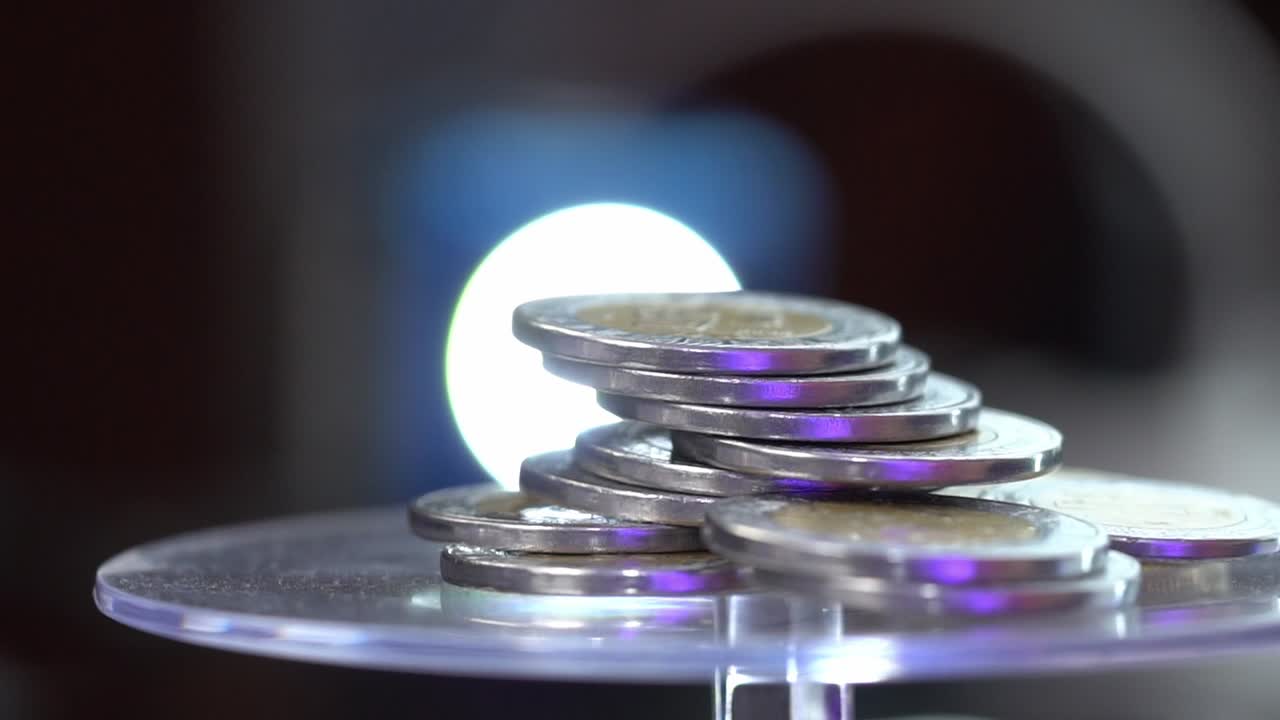 Stack of bimetallic coins with a glowing backlight for a financial concept