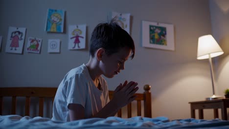 child praying in bed at night