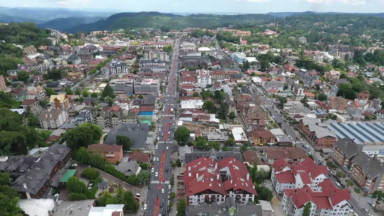 Ripresa aerea cinematografica ascendente con drone che rivela un'inquadratura di ambientazione del centro della città di Gramado, l'arteria principale e l'architettura europea a Rio Grande do Sul, Brasile. Video di alta qualità a 1080p 60fps