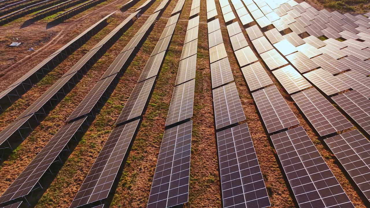 Solpaneler dækker store marker om dagen på et anlæg for vedvarende energi uden for byen, med rækker af paneler vendt mod solen