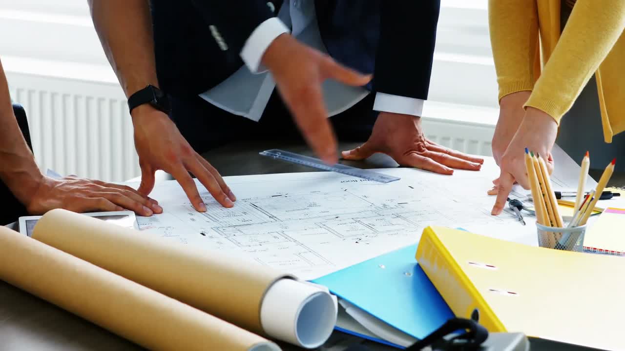 비즈니스 동료들이 청사진에 대해 논의하고 있습니다.