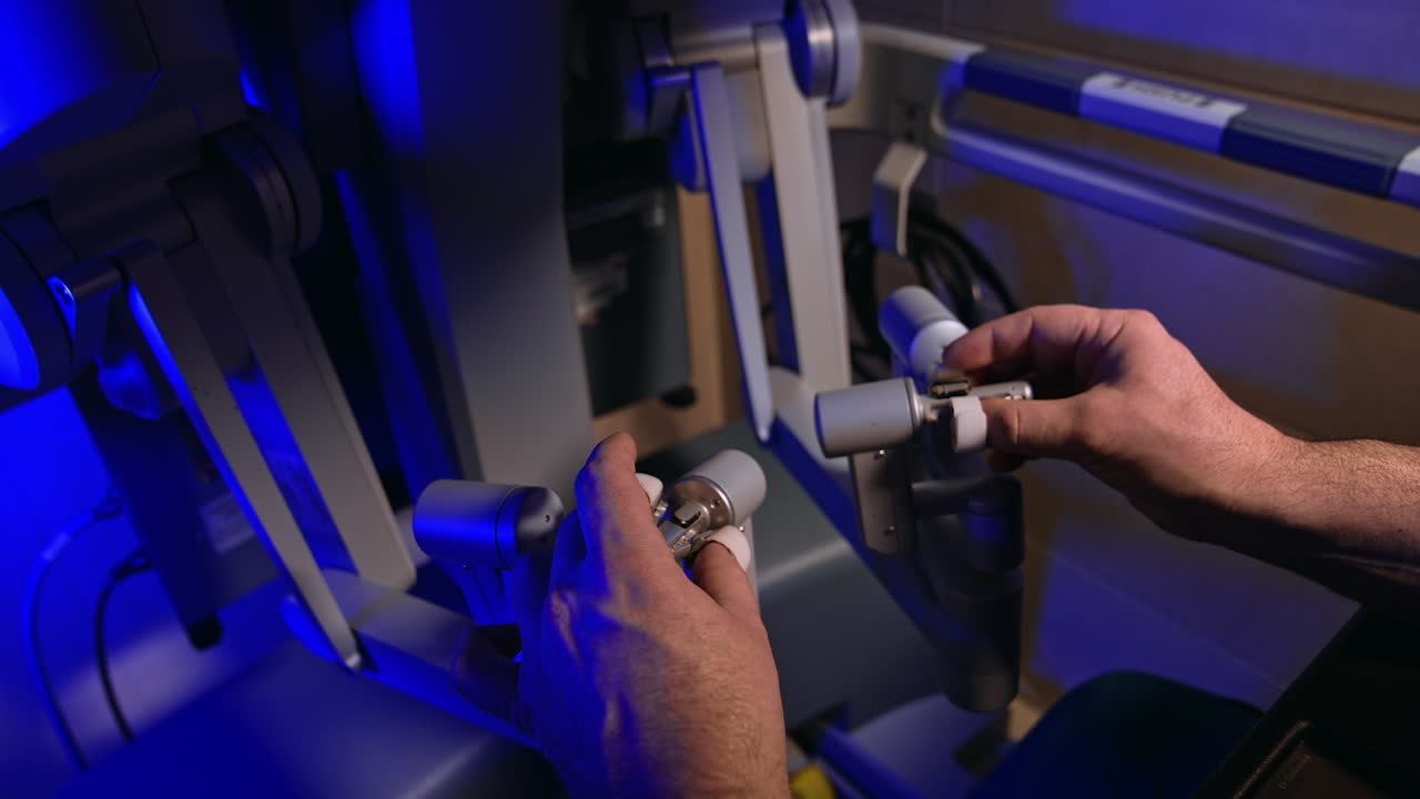 Surgeon's male hands take the handles of futuristic equipment. Doctor manages the arms of Da Vinci robot. Close up.