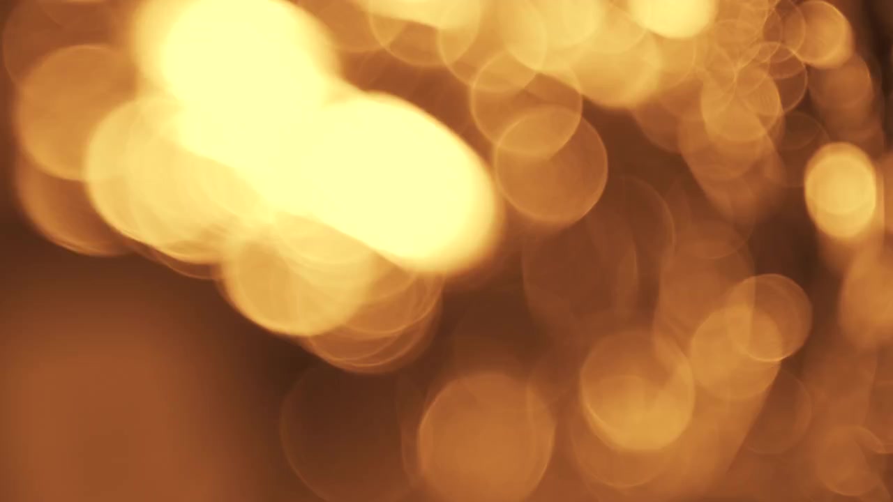 Particelle Bokeh Astratte di Luce Dorata Fluttuanti su Sfondo Nero
