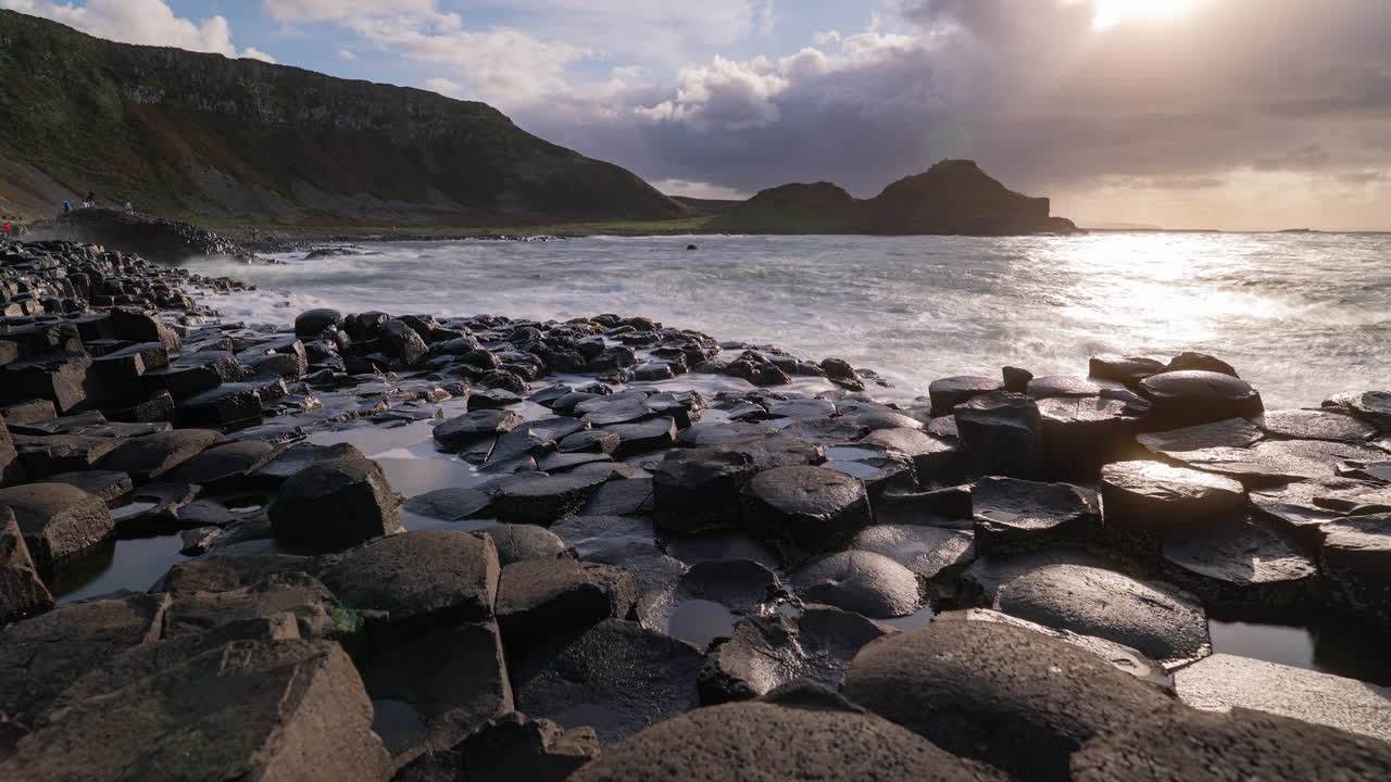 A long exposure time lapse of Giant's Causeway in Northern Ireland, the ocean swells in and out, water rushes off of the hexagon shaped basalt formations