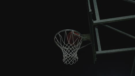 Pelota-De-Baloncesto-Golpeó-La-Canasta,-Anotó-En-La-Noche,-Vista-Oscura-De-ángulo-Bajo