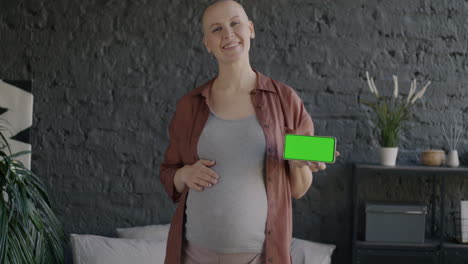 pregnant woman holding mobile phone with green screen