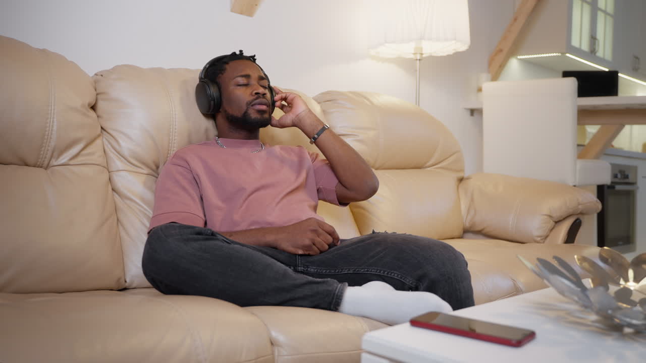 hombre relajándose en un sofá con auriculares