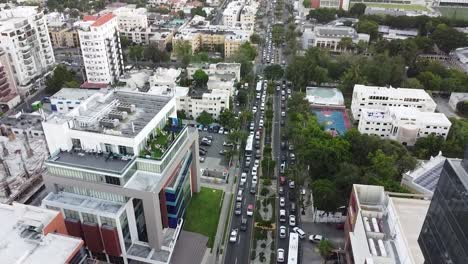 Drohnenaufnahmen-Der-Straßen-Von-Santo-Domingo,-Der-Hauptstraße-Nuñez-De-Caceres,-Kamerabewegungen-Mit-Fokus-Auf-Den-Berufsverkehr
