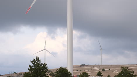 wind turbines on a hilltop under a cloudy sky