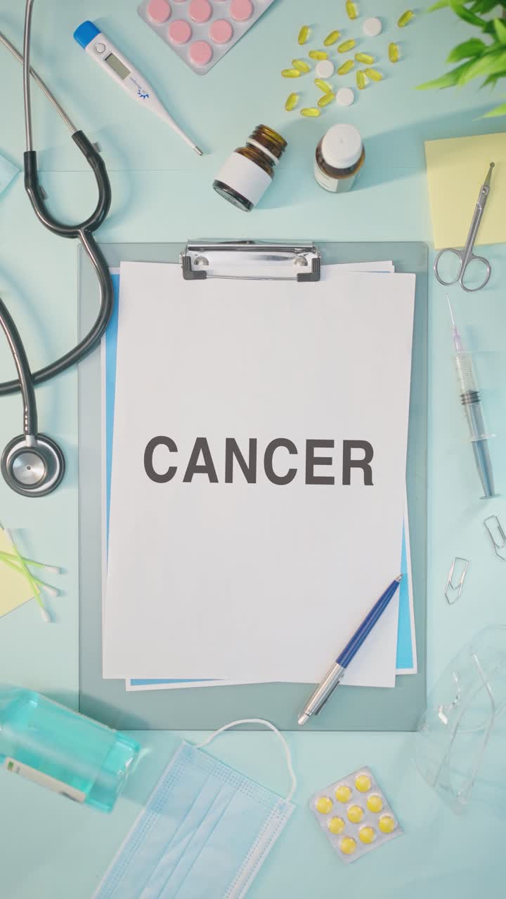 Video verticale della parola 'cancro' scritta su un referto medico