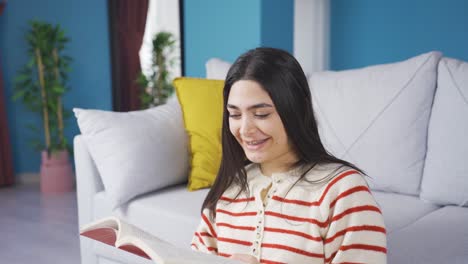 una joven feliz con aparatos que lee un libro.