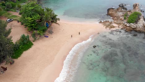 pedestal drone shot slightly panning to the left of a cove in ya nui, with its fine sand, crystal clear waters, and an idyllic picturesque scenery, located in the island of phuket in thailand