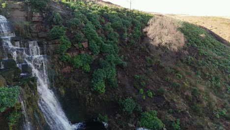 Aerial-drone-footage-of-a-tall-rocky-waterfall-in-the-Yorkshire-Dales,-Pennies