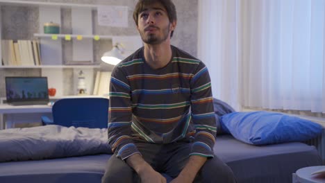 un joven pensativo que se siente infeliz en su habitación.