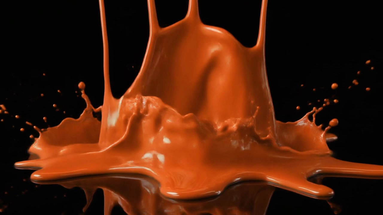 Liquido denso arancione che gocciola e schizza su superficie nera